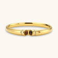 Polished gold bangle with two oval tiger's eye cabochons flanked by pavé diamond accents at center clasp.